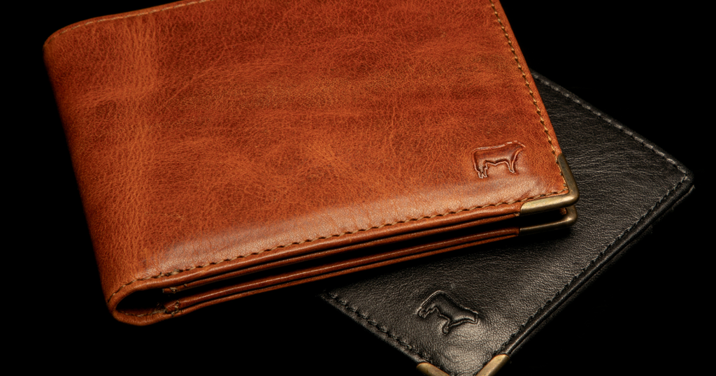 A black and brown genuine leather wallet by Will Leather Goods on a dark background.