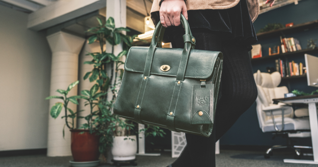 A woman carrying her green leather briefcase from Will Leather Goods.